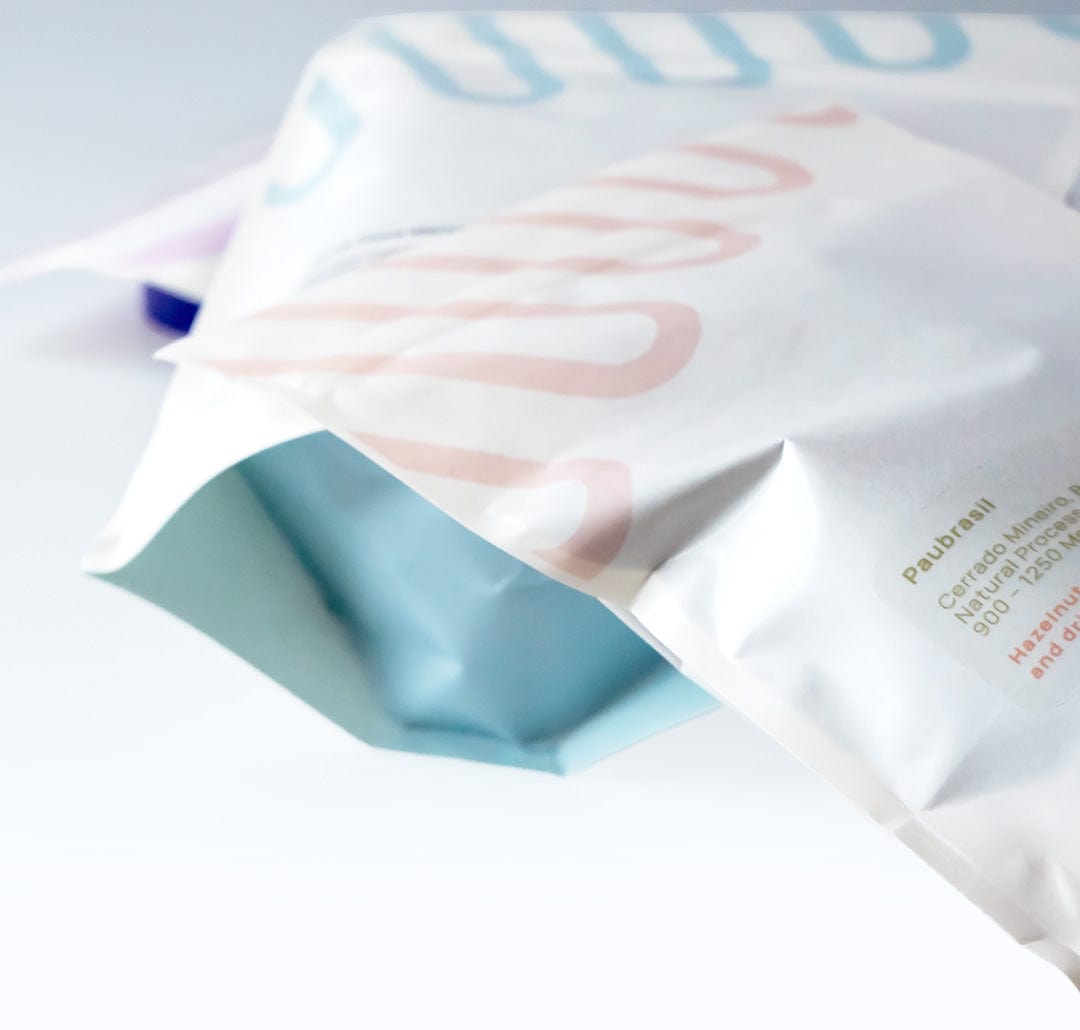 Loom Coffee Co. bags displayed in a flat-lay with coffee beans and vessels of brewed coffee. 