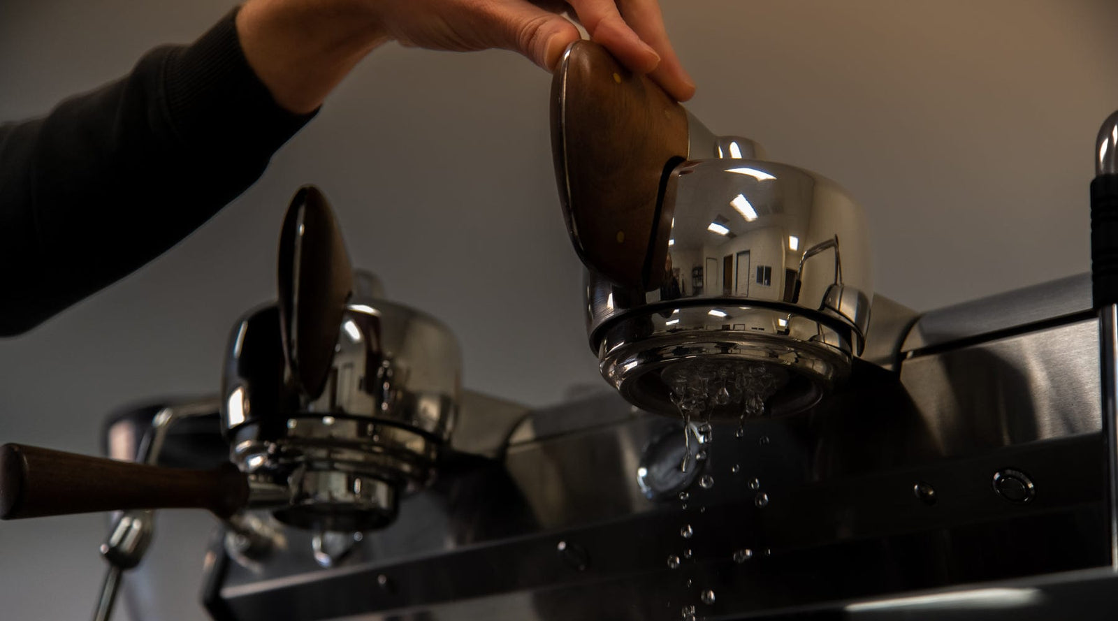 Water pouring through the portafilter basket of a Slayer Espresso V3 machine at the Loom Coffee Co. roasting facility.