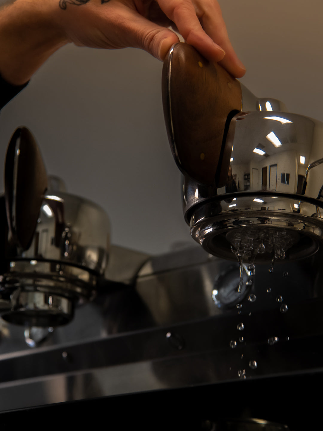 Water pouring through the portafilter basket of a Slayer Espresso V3 machine at the Loom Coffee Co. roasting facility.